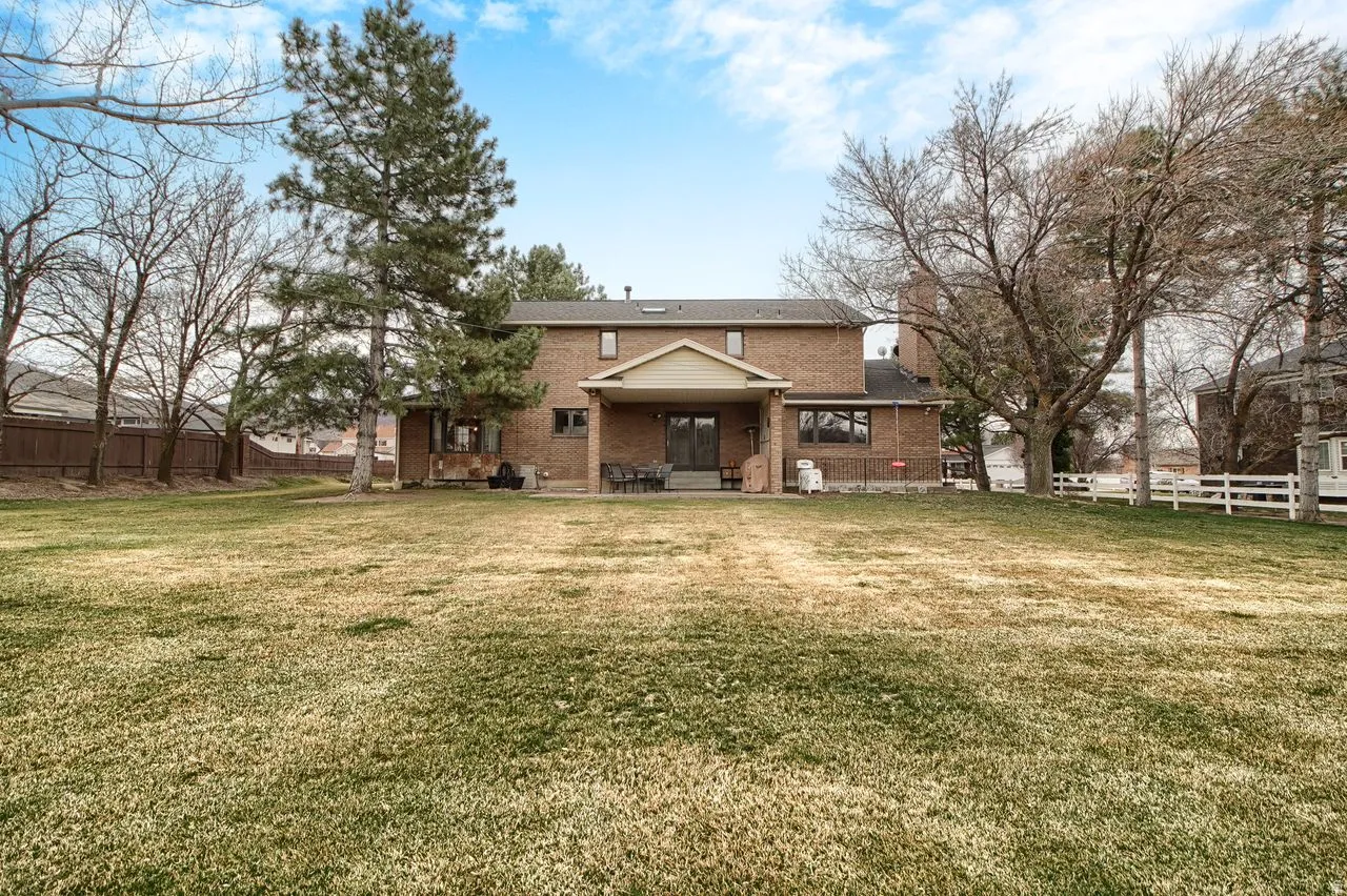 Rear view of house with brick siding and a patio area