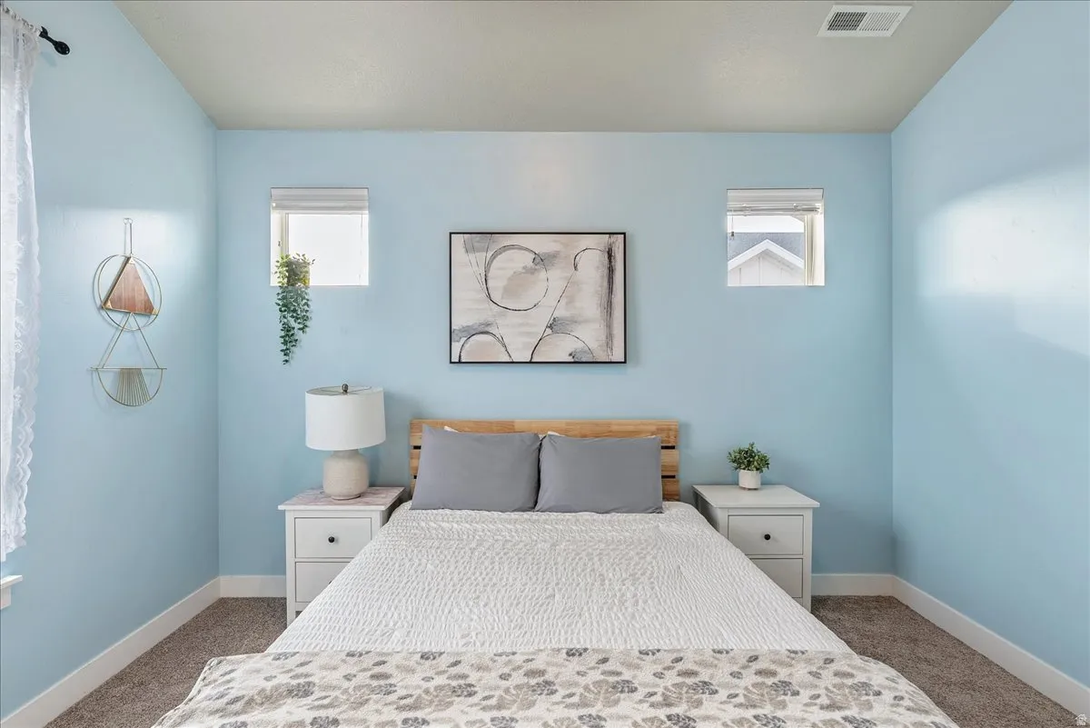 Bedroom featuring carpet floors and multiple windows