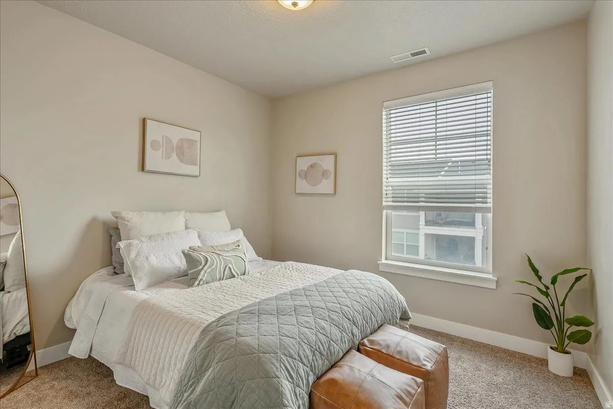 Bedroom featuring light carpet