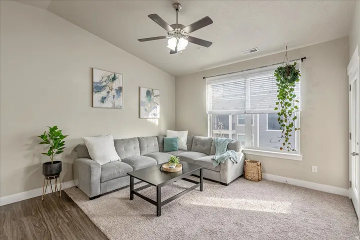 Living area with ceiling fan and lofted ceiling