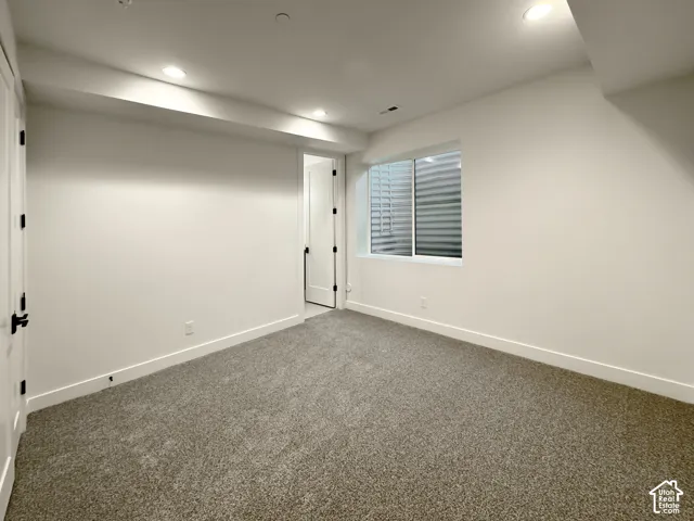 Finished below grade area featuring dark carpet and recessed lighting