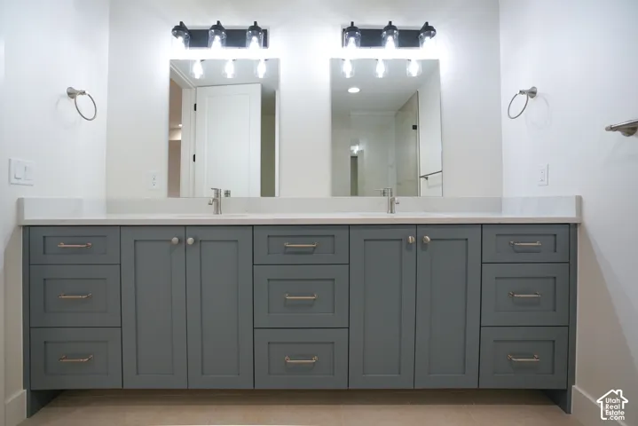 Bathroom featuring double vanity, a shower, and light tile patterned flooring