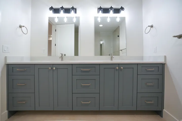 Bathroom featuring double vanity, a shower, and light tile patterned flooring