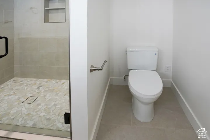 Full bathroom featuring a shower stall and light tile patterned floors