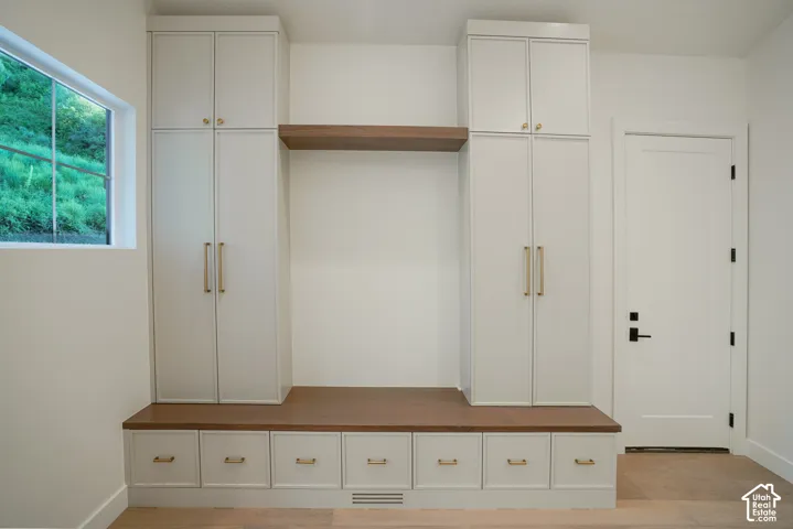 Mudroom featuring light wood-style flooring and baseboards