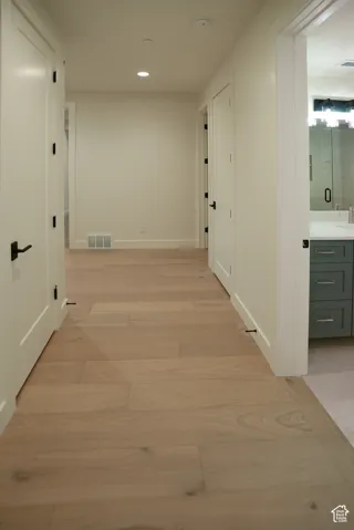 Hallway featuring light wood-type flooring and recessed lighting