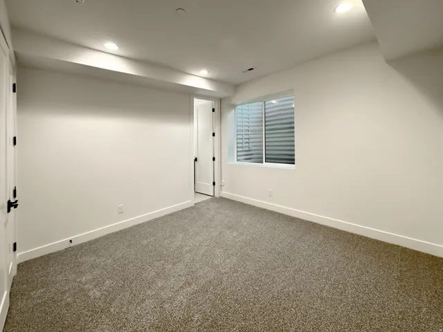 Finished below grade area featuring dark carpet and recessed lighting