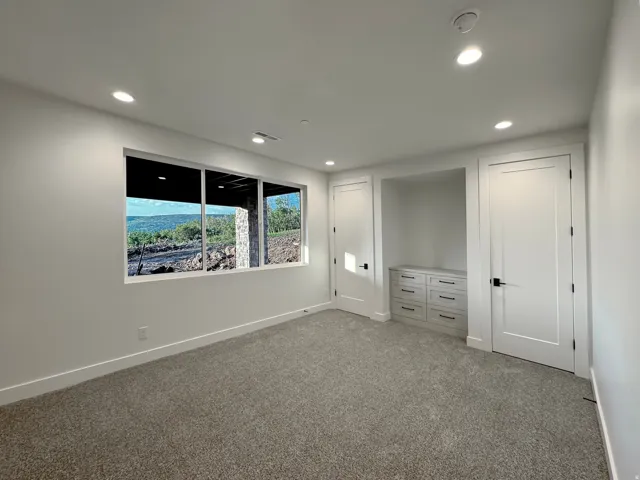 Unfurnished bedroom with carpet floors and recessed lighting