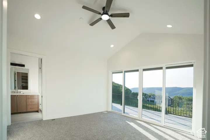 Spare room with light carpet, a high ceiling, recessed lighting, a ceiling fan, and a mountain view