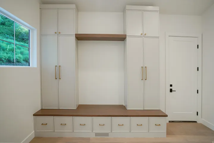 Mudroom featuring light wood-style flooring and baseboards