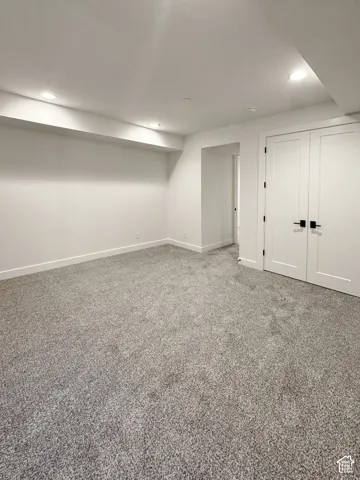 Finished below grade area with carpet flooring and recessed lighting