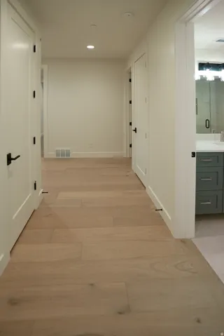 Hallway featuring light wood-type flooring and recessed lighting
