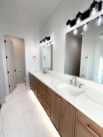 Full bath featuring double vanity and toilet