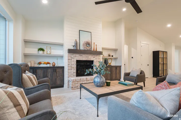 Living room with recessed lighting, wood finished floors, built in features, a fireplace, and a ceiling fan