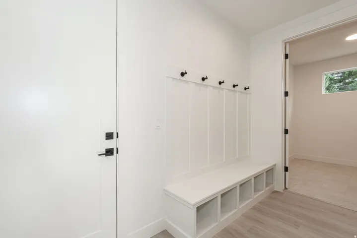 Mudroom with light wood-type flooring and baseboards