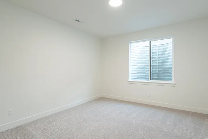 Spare room with baseboards and light carpet