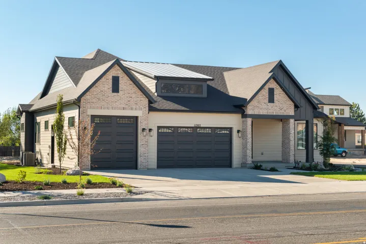 Craftsman-style house featuring a garage, concrete driveway, brick siding, board and batten siding