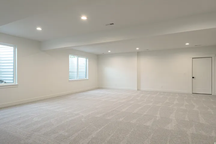 Below grade area featuring recessed lighting and light colored carpet