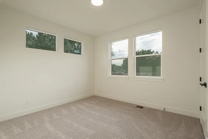 Carpeted spare room featuring baseboards