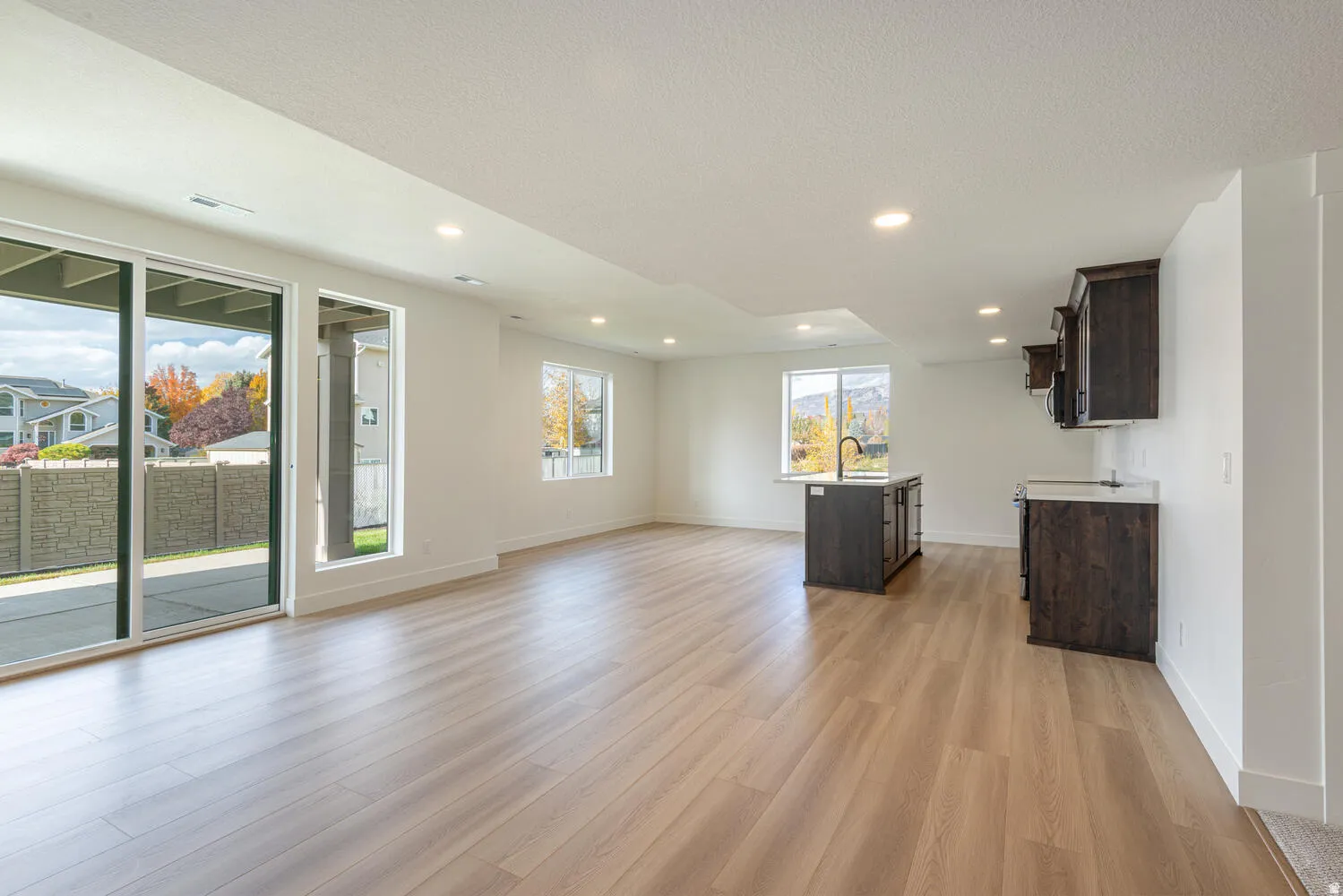 Unfurnished living room featuring light wood-type flooring, a textured ceiling, and recessed lighting