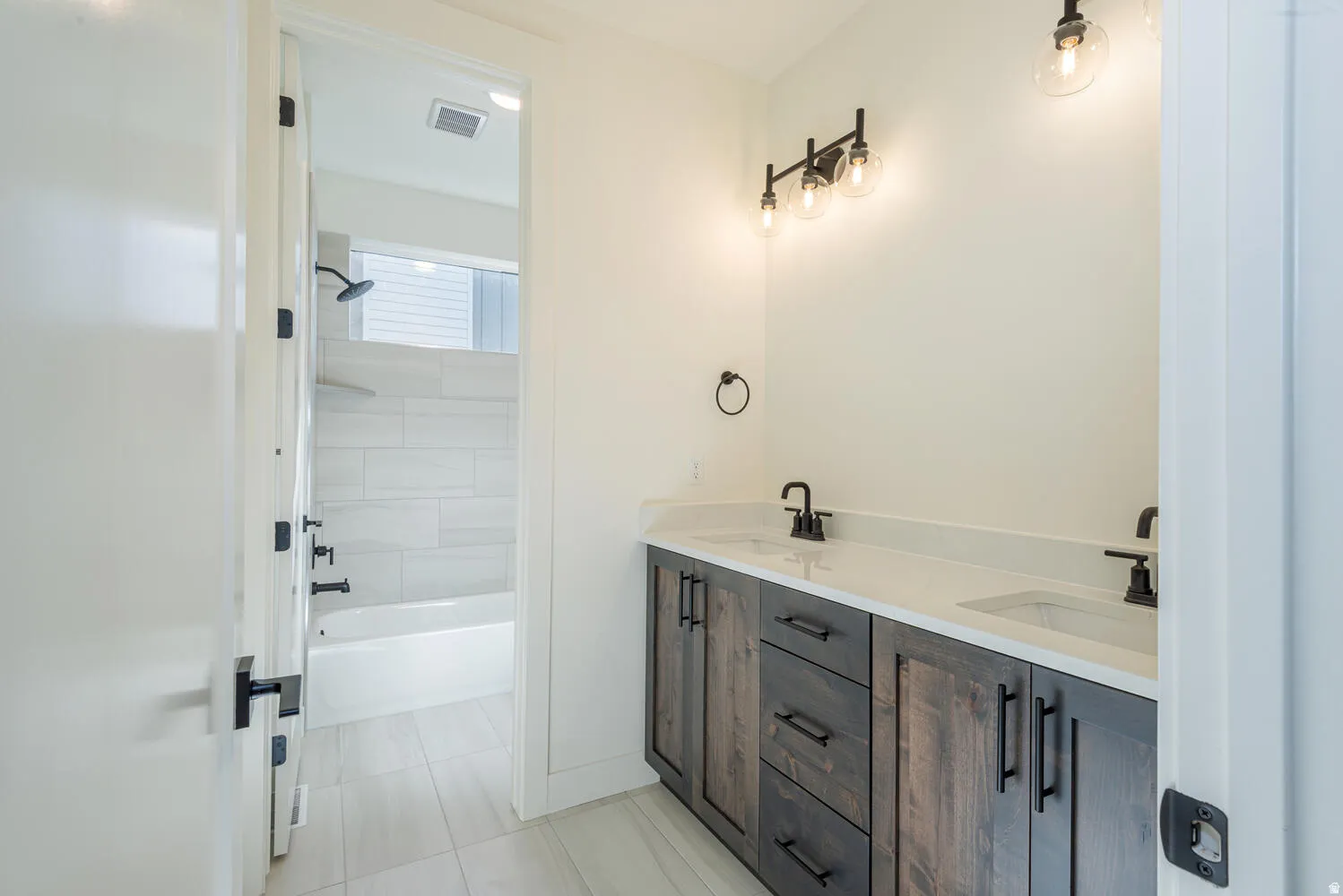 Full bath with double vanity and bathtub / shower combination