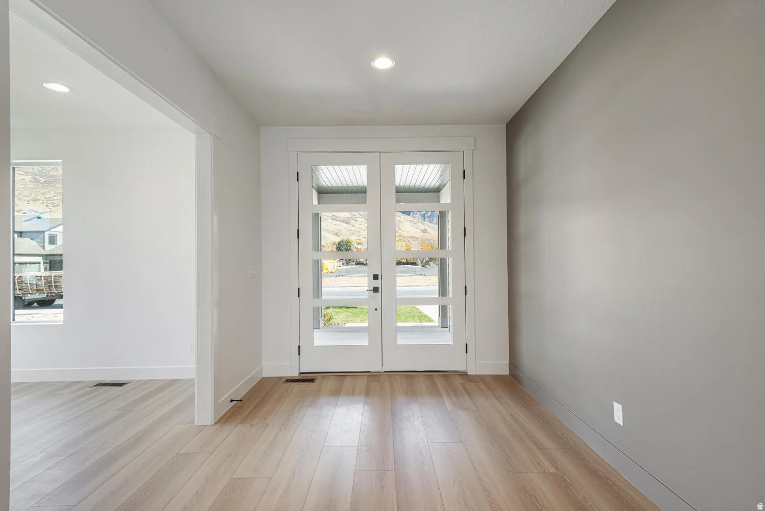 Doorway featuring french doors, wood finished floors, and plenty of natural light