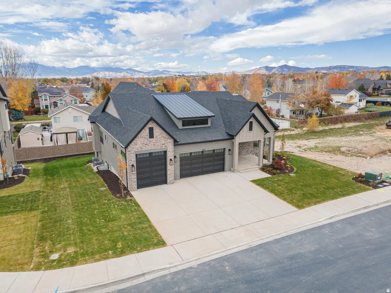 View of front of home with a residential view, a shingled roof, solar panels, a front yard, and concrete driveway