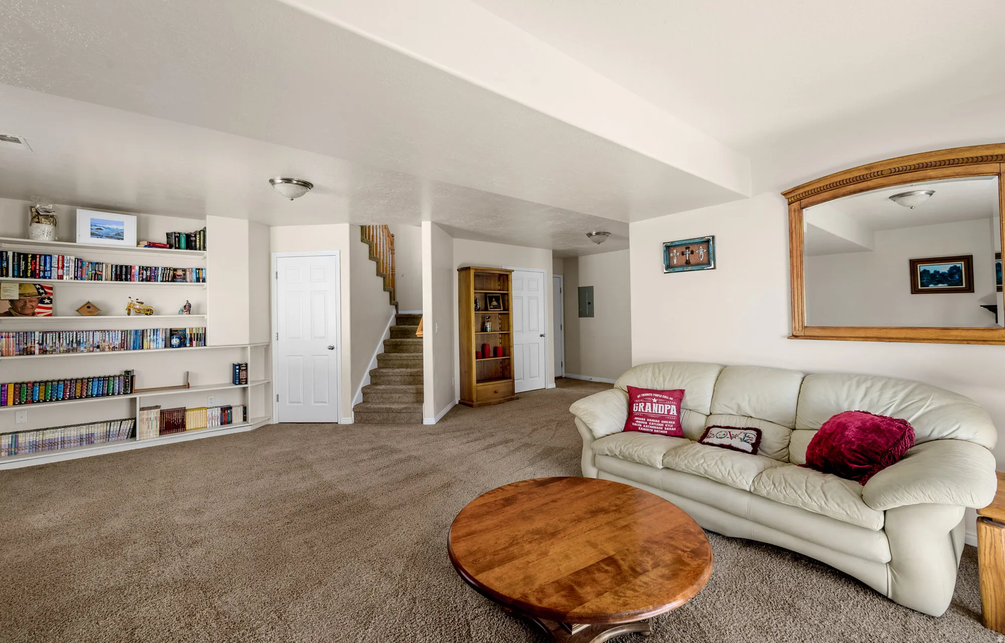 Carpeted living room with stairs and baseboards