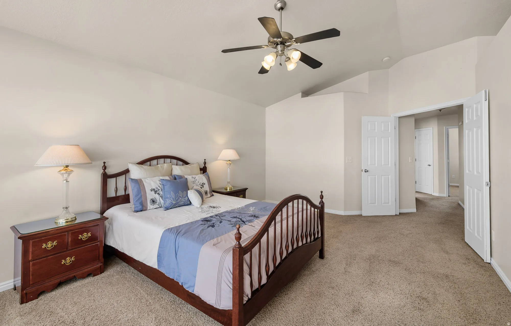 Master Bedroom featuring ceiling fan, light carpet, and vaulted ceiling