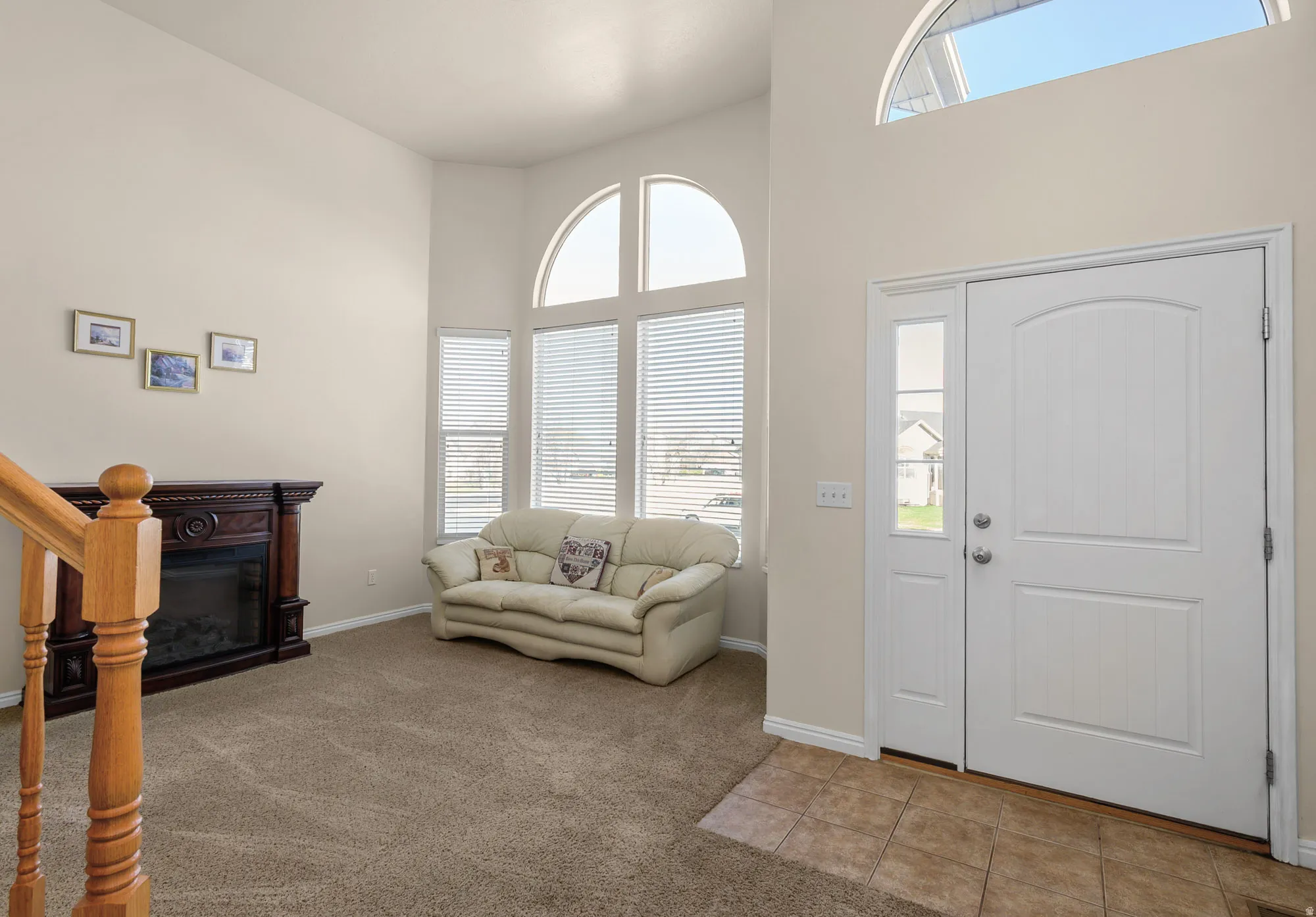 Entrance foyer featuring plenty of natural light, light carpet, a high ceiling,  and light tile patterned floors