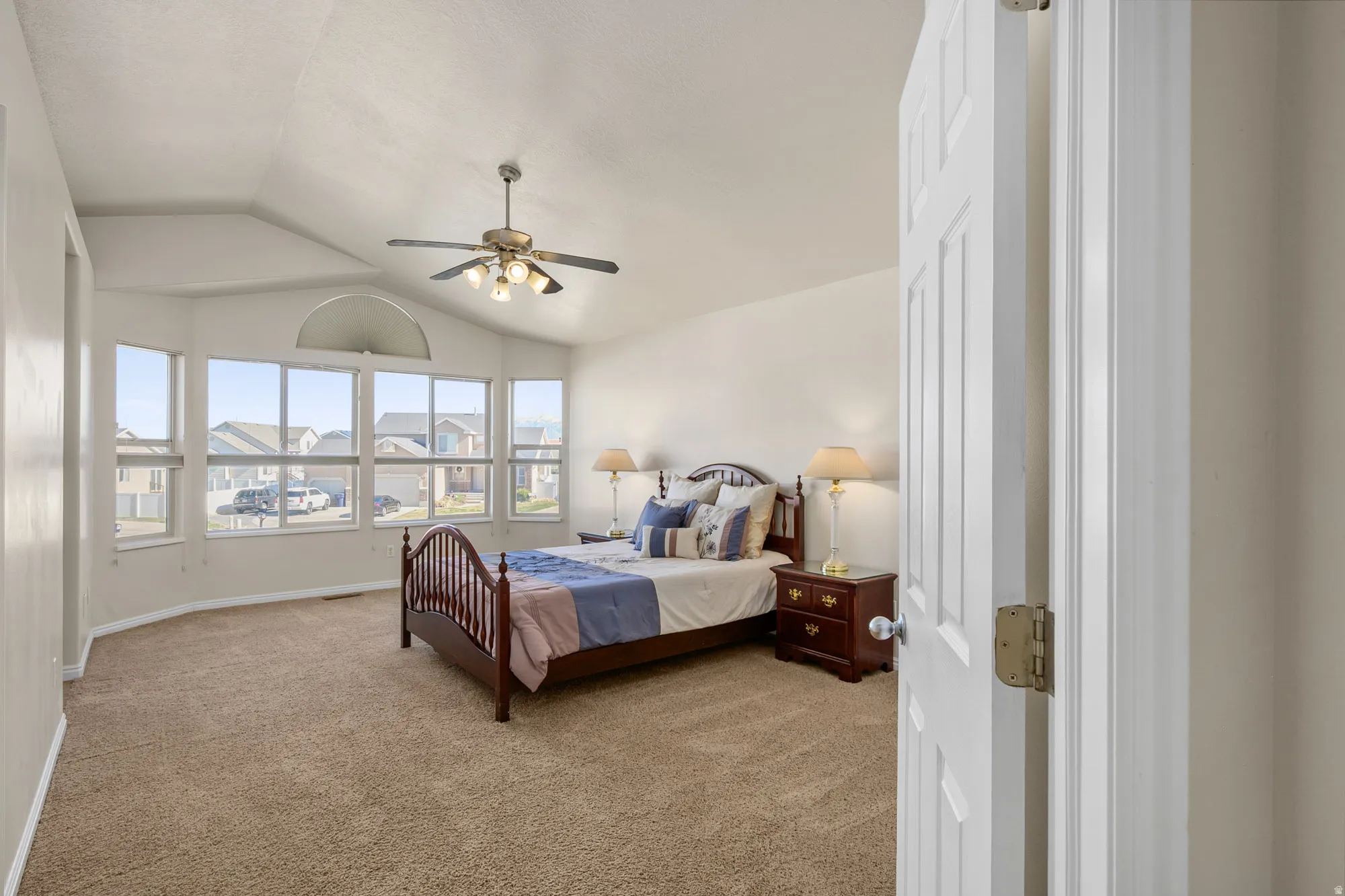 Master Bedroom with light colored carpet and a ceiling fan