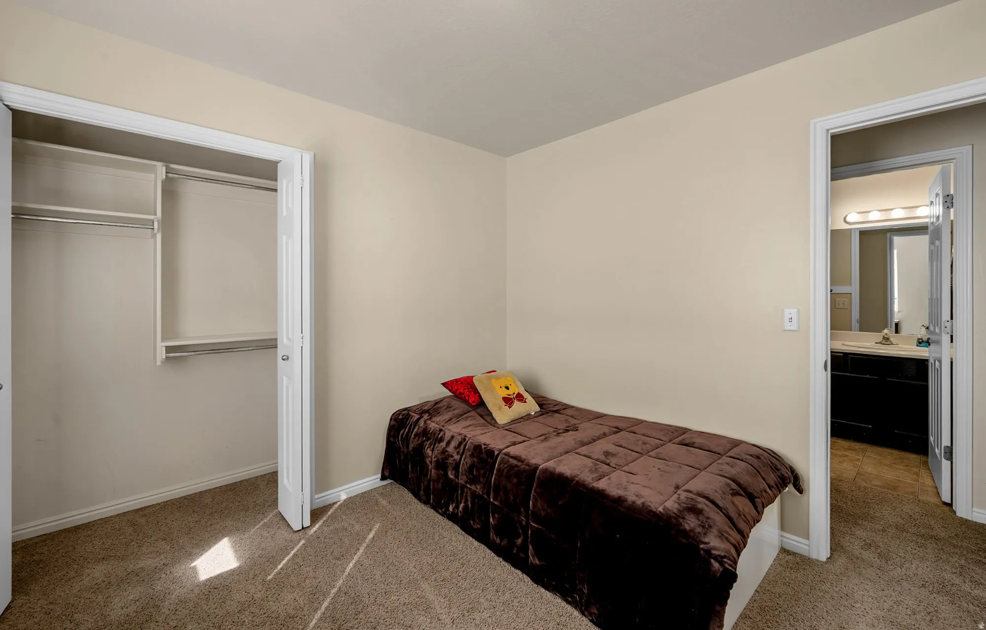 Bedroom featuring light carpet and a closet