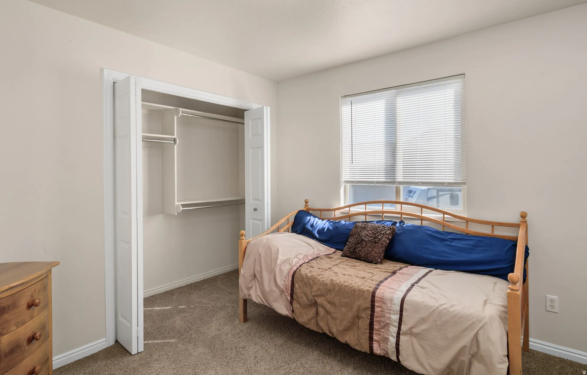 Carpeted bedroom with a closet and baseboards