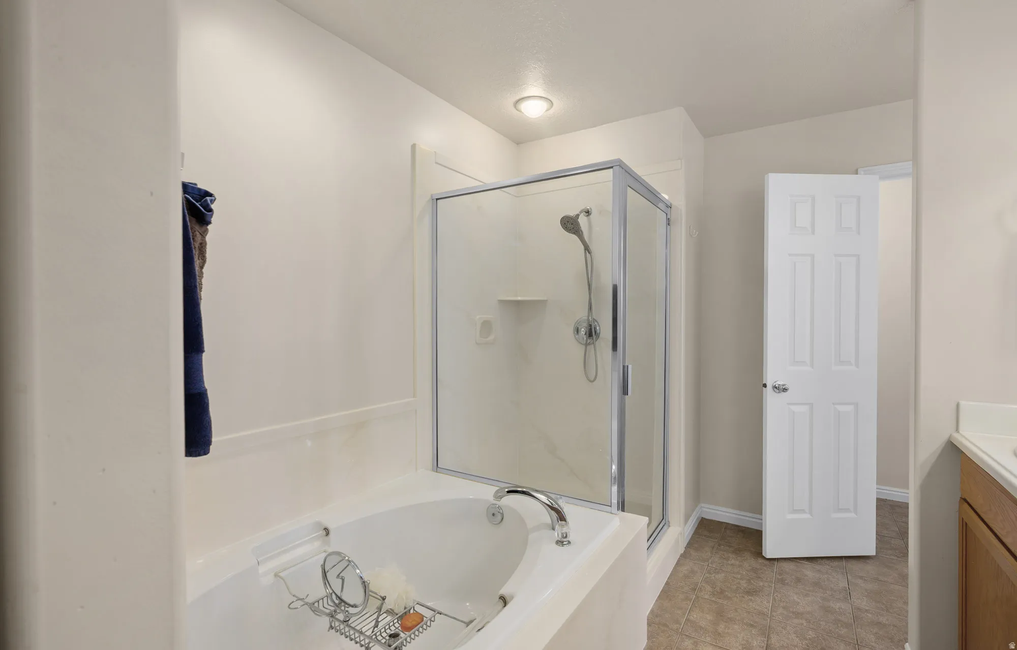 Master Bathroom with vanity, a bath, a stall shower, and light tile patterned floors