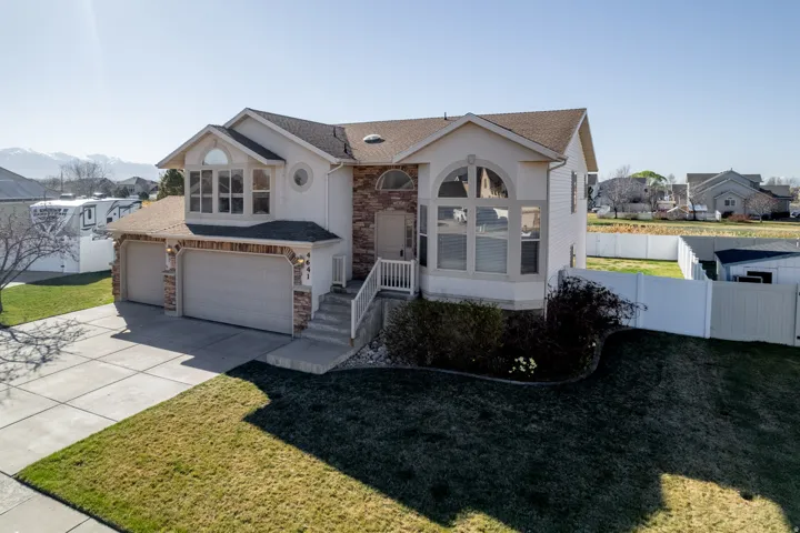 View of front of house featuring stone siding, concrete driveway, stucco siding, a 3 car garage, and roof with shingles