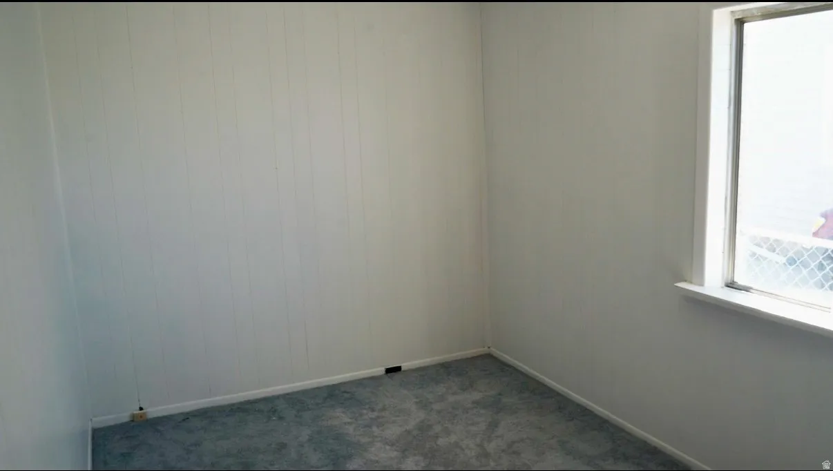 Unfurnished room with dark carpet