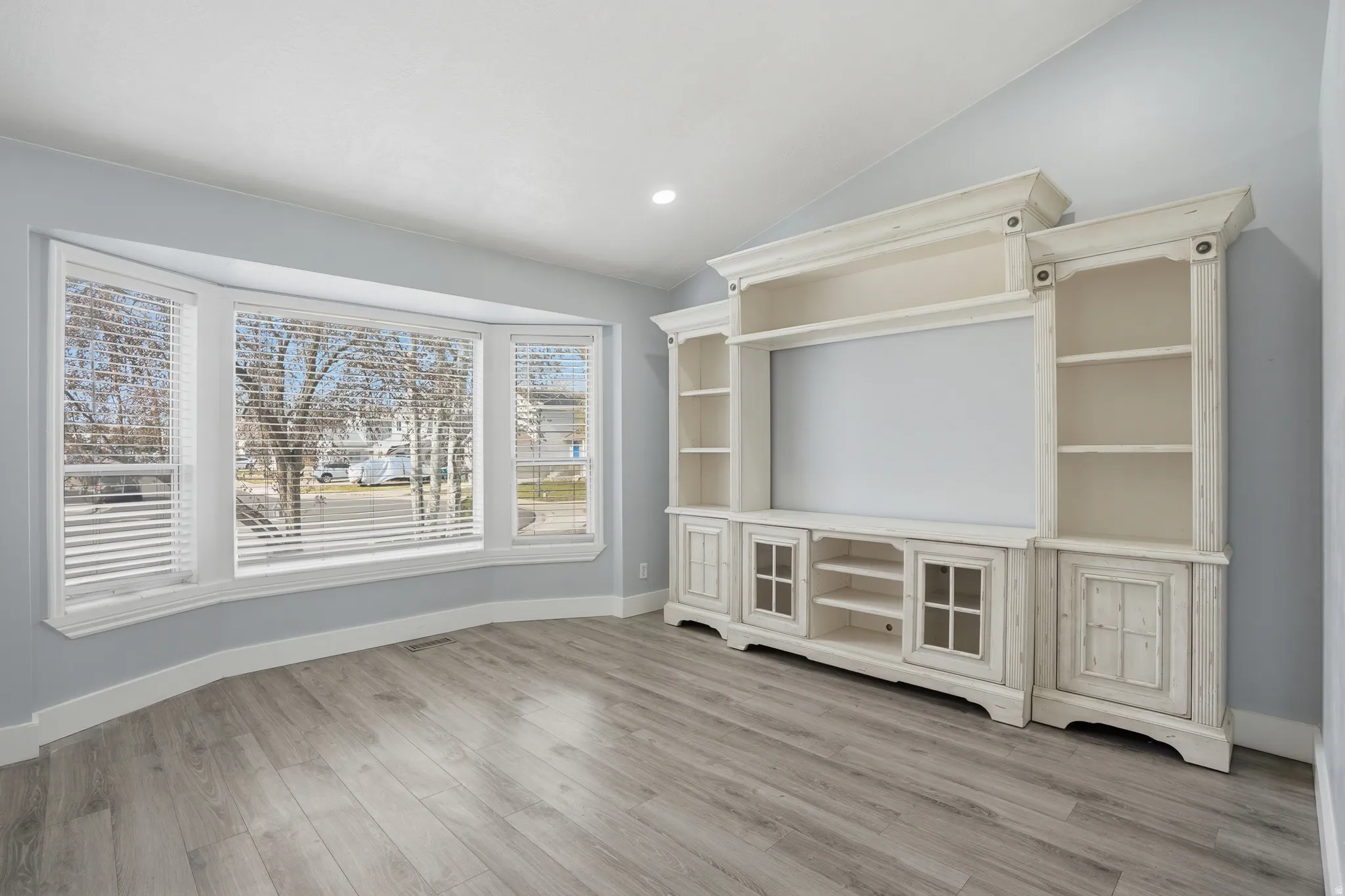 Unfurnished living room with recessed lighting, light wood-style flooring, and vaulted ceiling