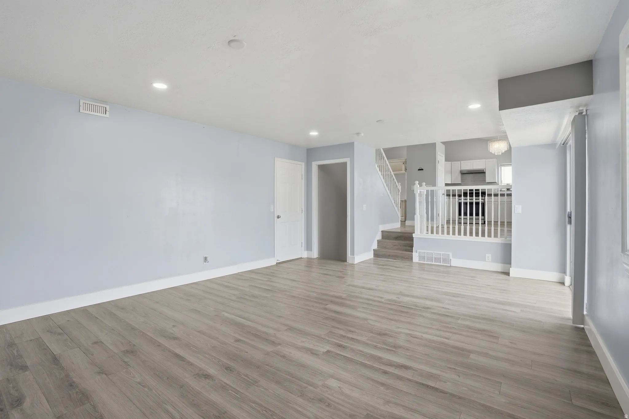 Unfurnished living room with light wood finished floors and recessed lighting