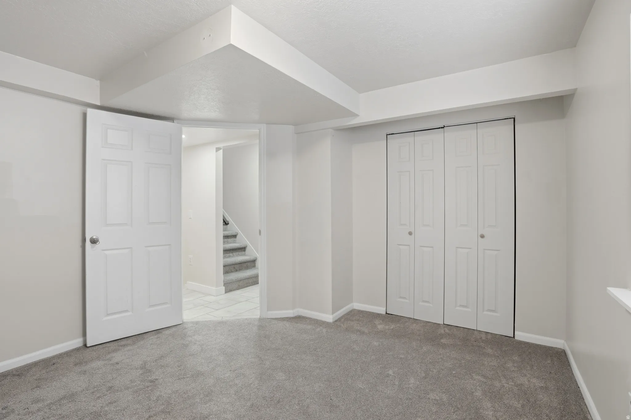 Finished basement with light colored carpet