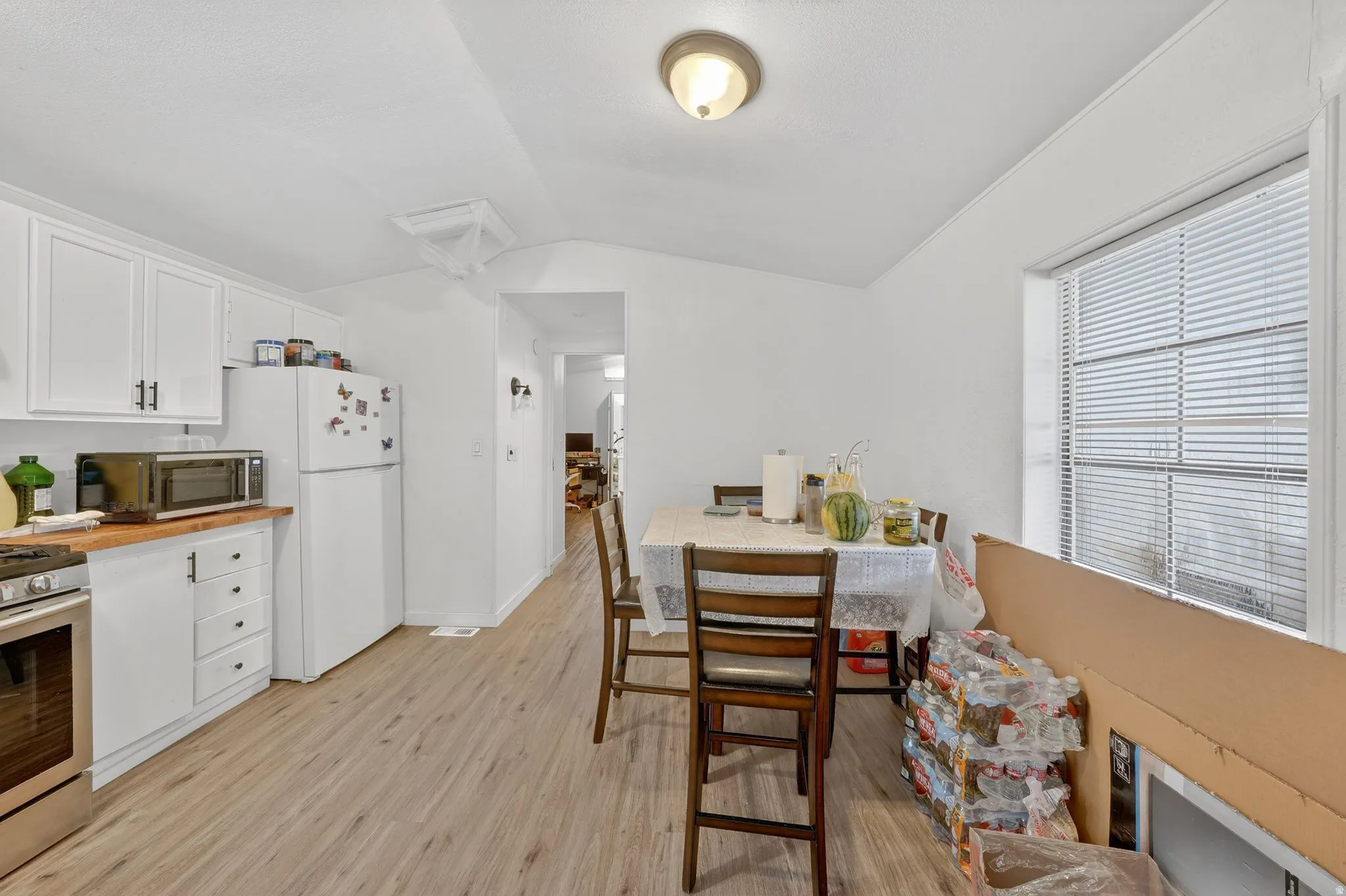 Dining area featuring lofted ceiling and light wood finished floors