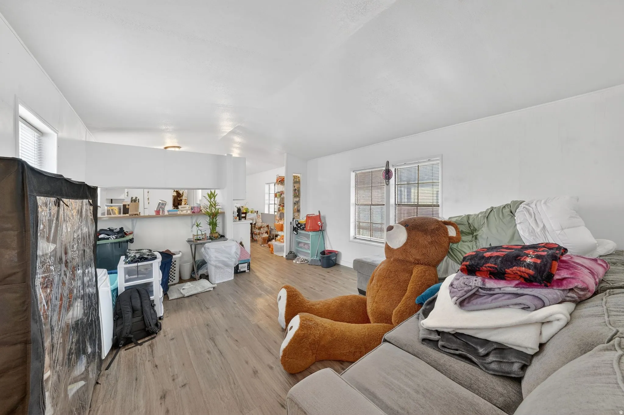 Living area with light wood-type flooring and vaulted ceiling
