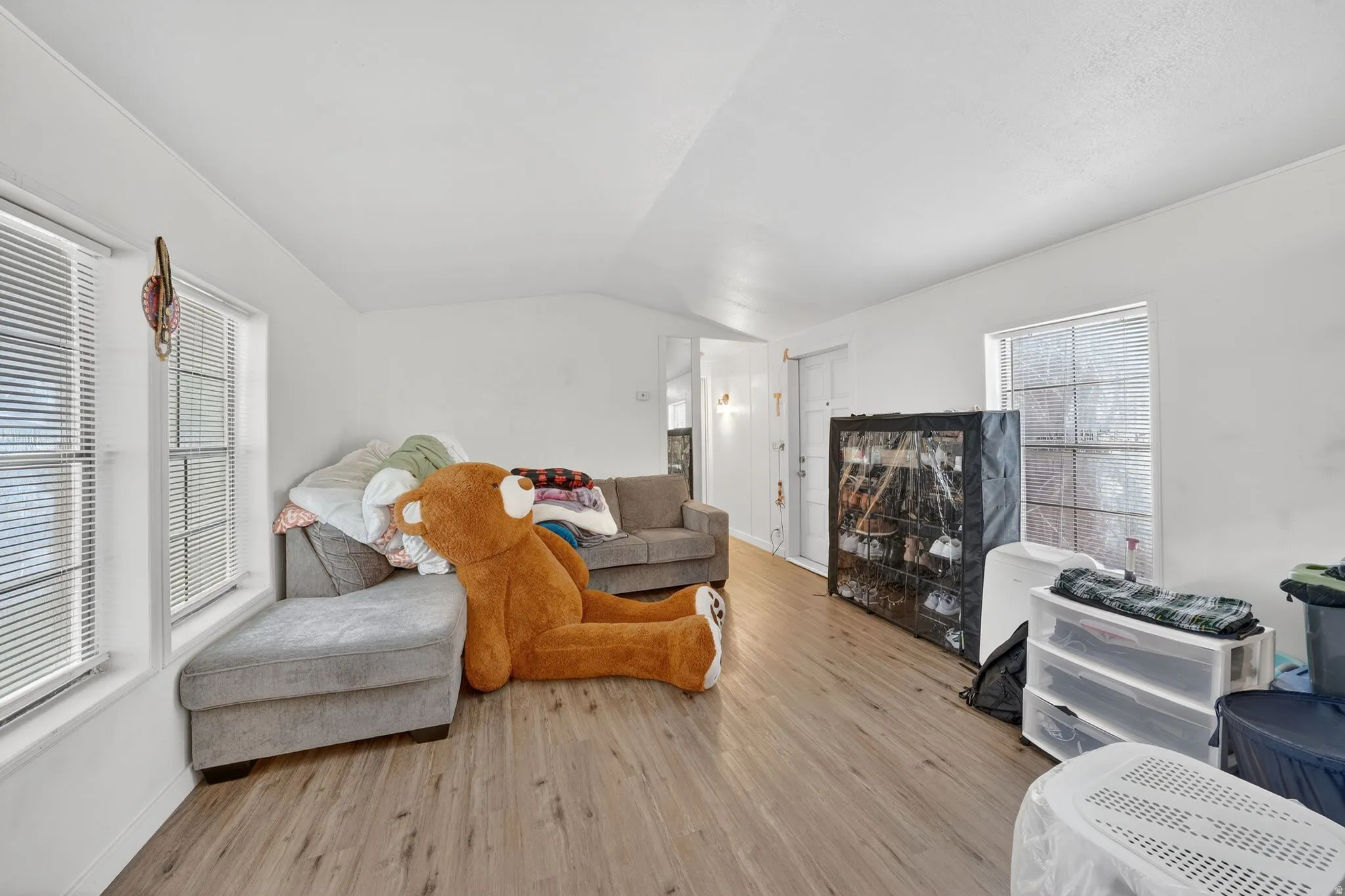 Living area with vaulted ceiling and wood finished floors