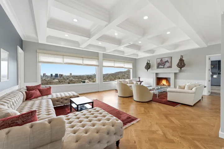 Living area featuring wainscoting, coffered ceiling, parquet flooring, a lit fireplace, and recessed lighting