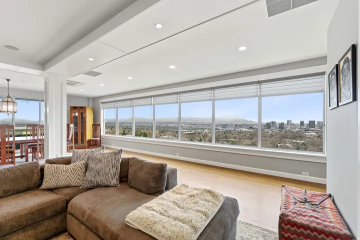 Living room with decorative columns, wood finished floors, healthy amount of natural light, and suspended lighting
