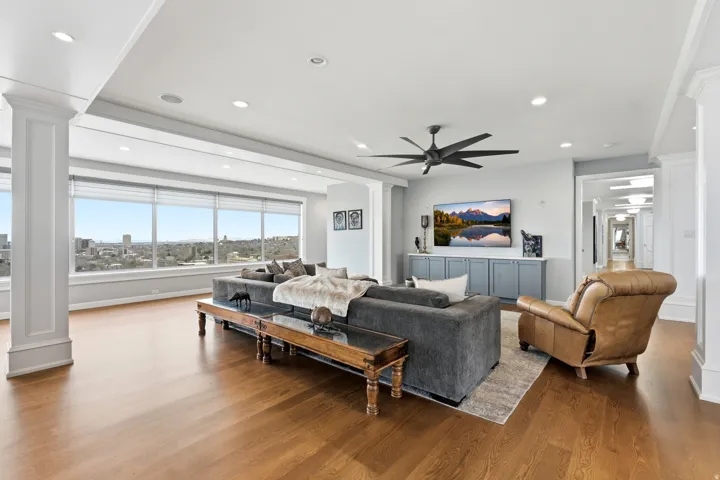 Living area featuring ornate columns, wood finished floors, recessed lighting, and ceiling fan