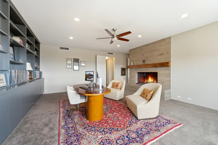 Carpeted living room featuring a tile fireplace, ceiling fan, and recessed lighting