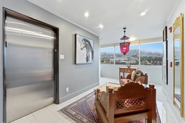 Living area featuring a mountain view, elevator, light tile patterned floors, crown molding, and recessed lighting