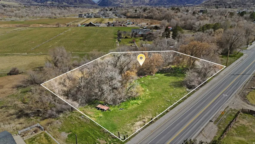 Overview of rural landscape with property parcel outlined and a mountainous background