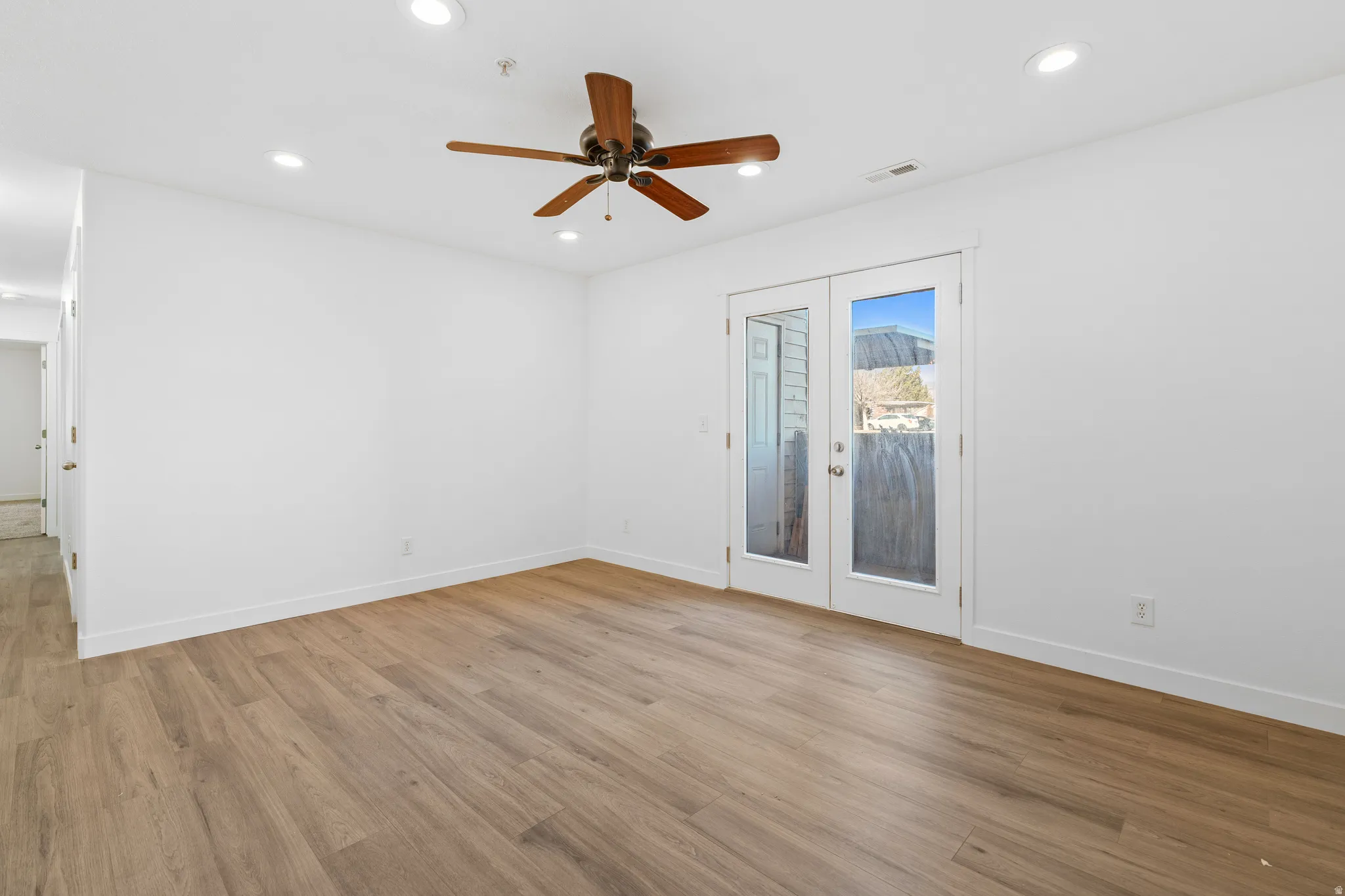 Empty room featuring french doors, recessed lighting, ceiling fan, and light wood-style flooring