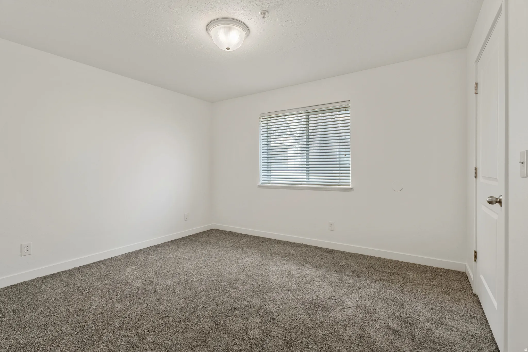 Unfurnished room with baseboards and dark carpet